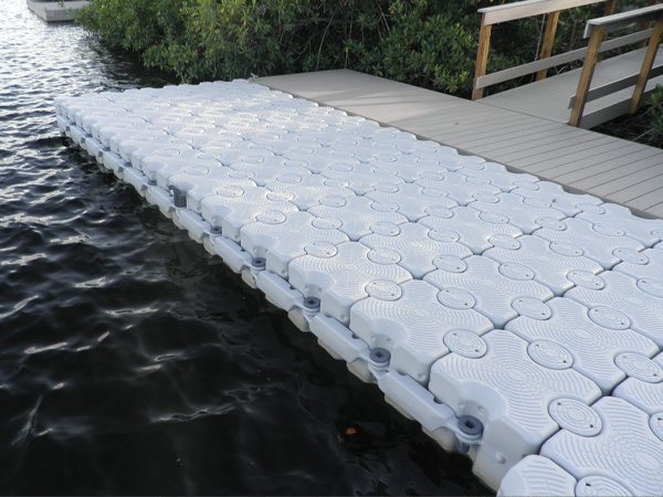 Dock Blocks floating dock next to a wooden pier in the water.