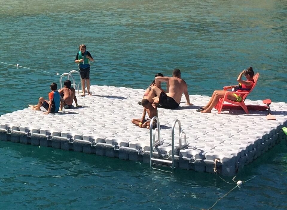 A floating swim platform with people hanging out