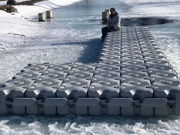 A women sitting on an L-shape dock in the snow