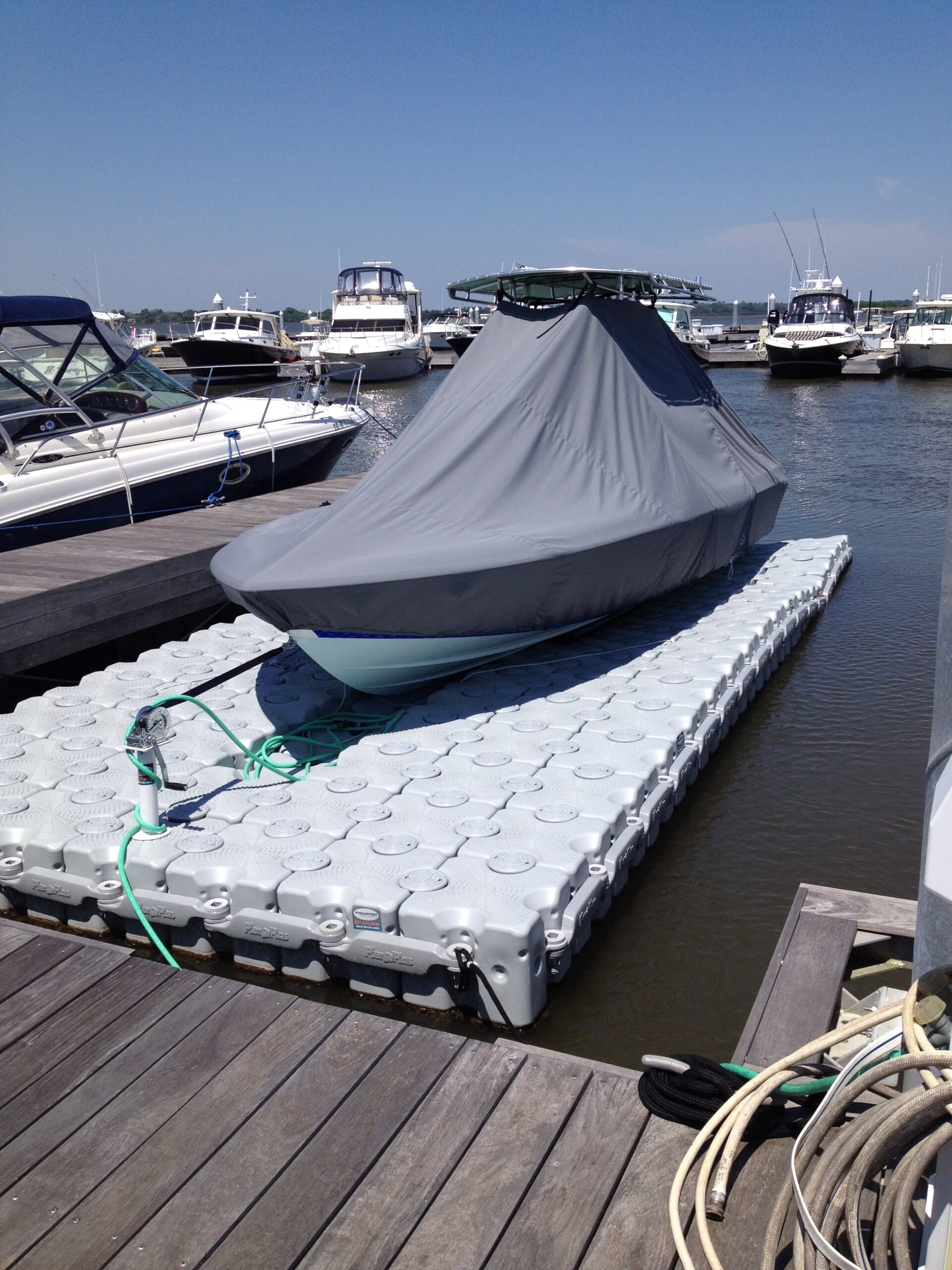 A covered boat sitting on a floating dock.