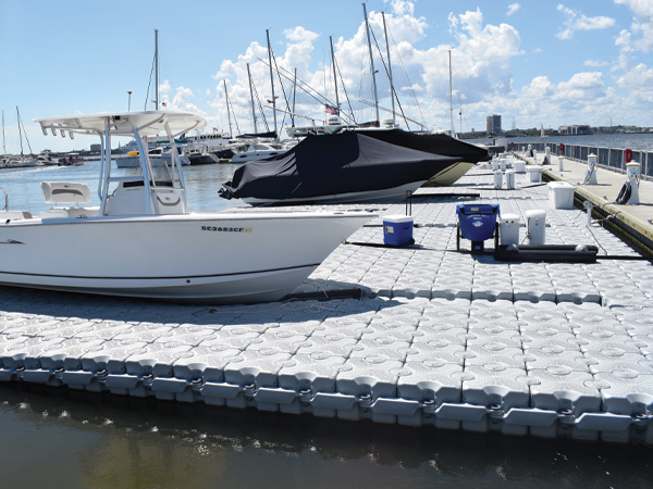 A marina full of boats sitting on a floating dock.