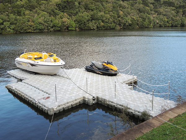 A small speedboat and a ski jet on a floating dock.