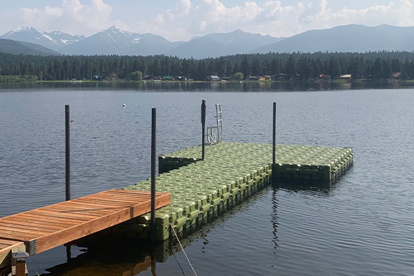 green fishing docks on the lake with mountains in the back