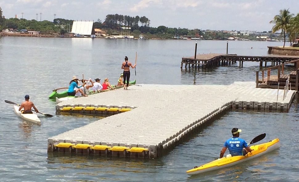 People boarding kayaks from a floating dock
