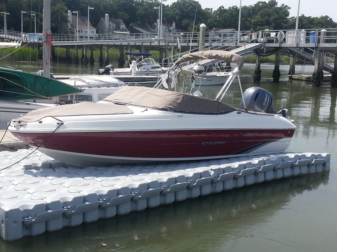 A speed boat sitting on a floating dock.